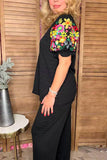 Black v-neck top with colorful embrodiery puff sleeves