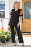 Black v-neck top with colorful embroidery puff sleeves